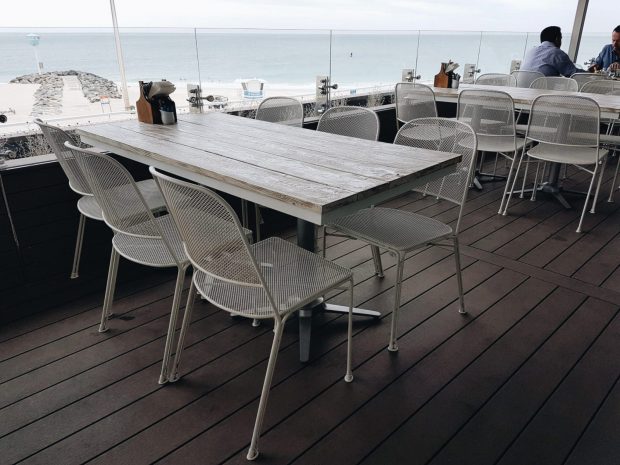 Hamptons City Beach on the outdoor balcony featuring NOROCK Esplanade self-stabilising table base